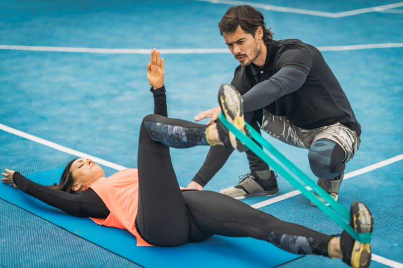 ćwiczenia z gumami oporowymi - rowerek w asyście partnera