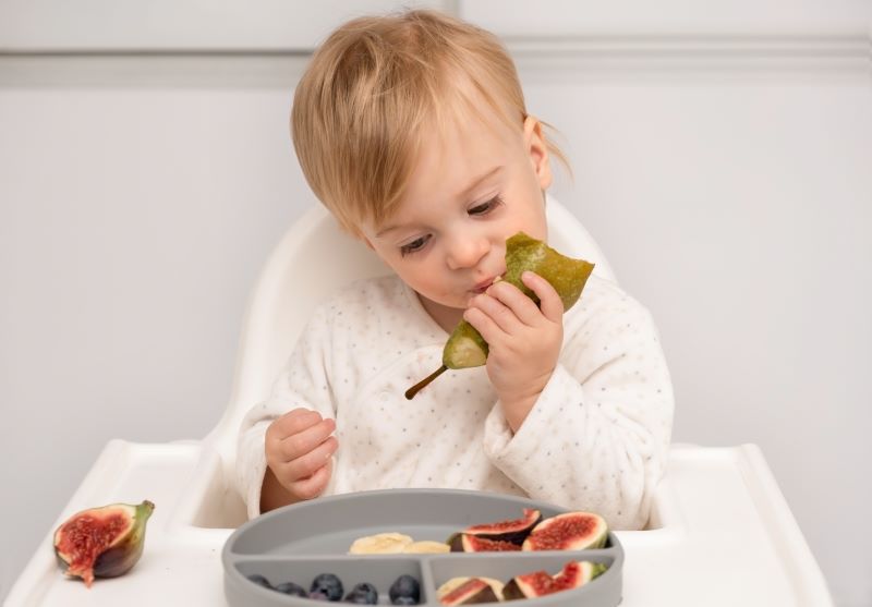 Dziecko jedzące owoce z witaminą c