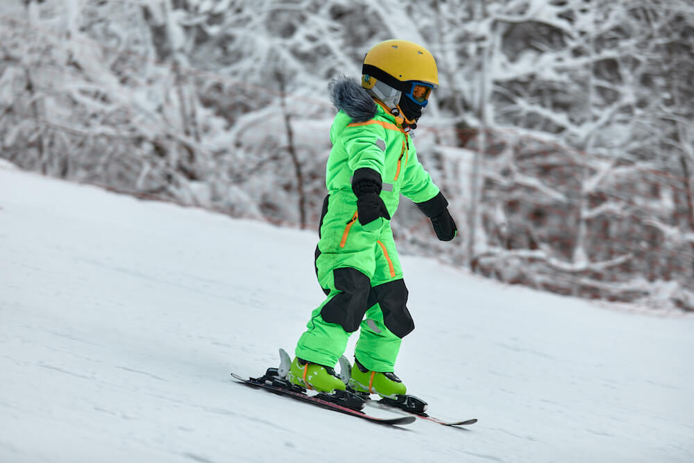 Nauka jazdy dla dziecka w zielonym kombinezonie