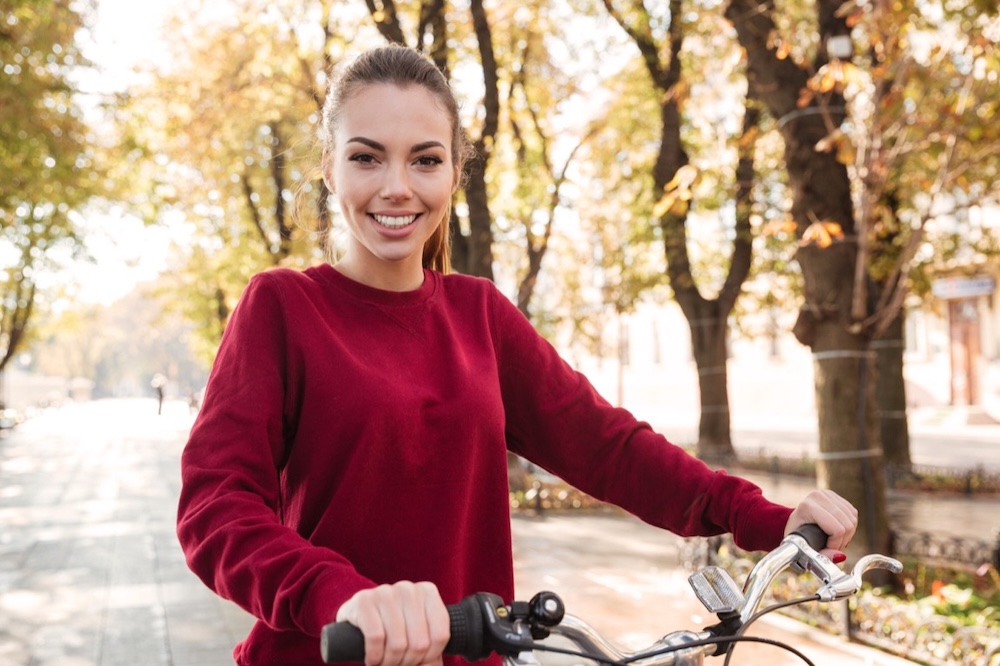 szczęśliwa kobieta w parku na rowerze 